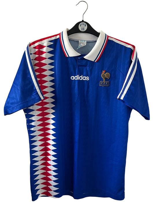 Maillot de foot vintage domicile bleu de l'Equipe de France 1994. On peut retrouver l'équipementier Adidas. Il s'agit d'un maillot authentique d'époque.