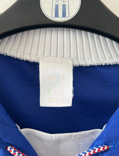 Maillot de foot vintage domicile bleu de l'équipe de france 1996. On peut retrouver l'équipementier Adidas. Il s'agit d'un maillot authentique d'époque.