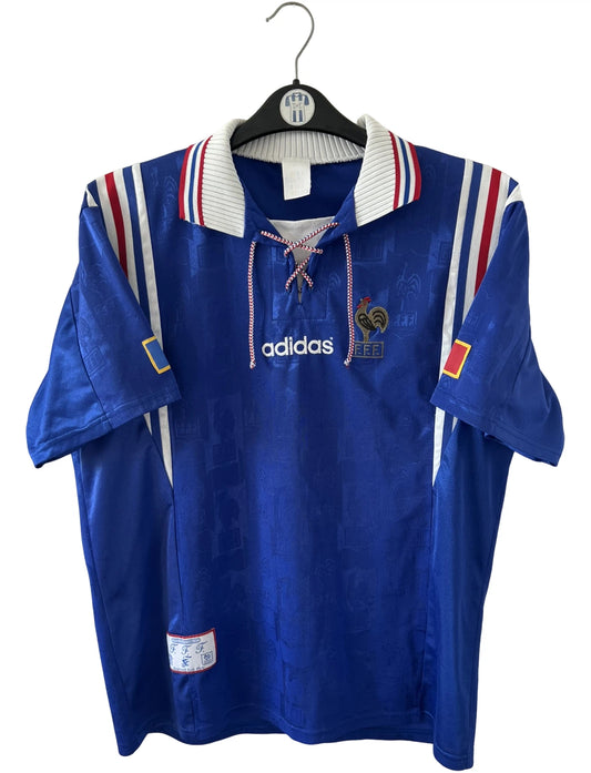 Maillot de foot vintage domicile bleu de l'équipe de france 1996. On peut retrouver l'équipementier Adidas. Il s'agit d'un maillot authentique d'époque.