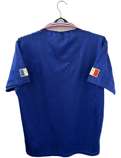 Maillot de foot vintage domicile bleu de l'équipe de france 1996. On peut retrouver l'équipementier Adidas. Il s'agit d'un maillot authentique d'époque.
