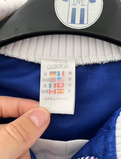 Maillot de foot vintage domicile bleu de l'équipe de france 1996. On peut retrouver l'équipementier Adidas. Il s'agit d'un maillot authentique d'époque.