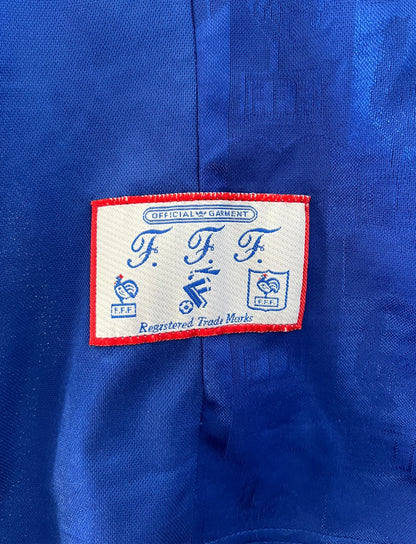 Maillot de foot vintage domicile bleu de l'équipe de france 1996. On peut retrouver l'équipementier Adidas. Il s'agit d'un maillot authentique d'époque.