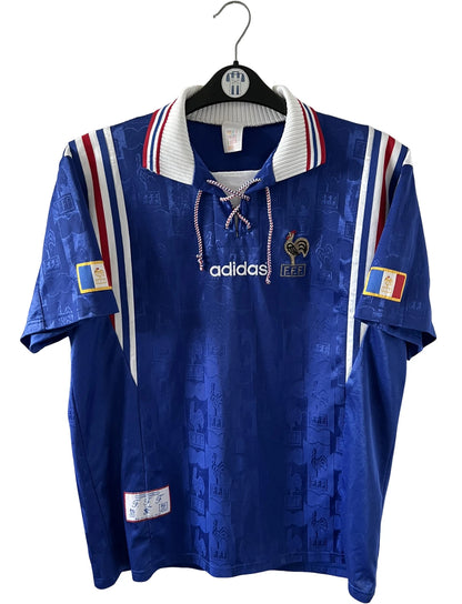 Maillot de foot vintage domicile bleu de l'équipe de france 1996. On peut retrouver l'équipementier Adidas. Il s'agit d'un maillot authentique d'époque.