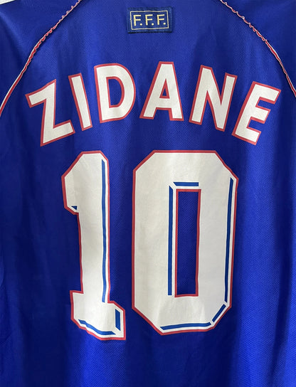 Maillot foot vintage domicile equipe de france 1998 bleu blanc et rouge. On peut retrouver l'équipementier adidas. Ils 'agit d'un maillot authentique d'époque floqué Zinedine Zidane