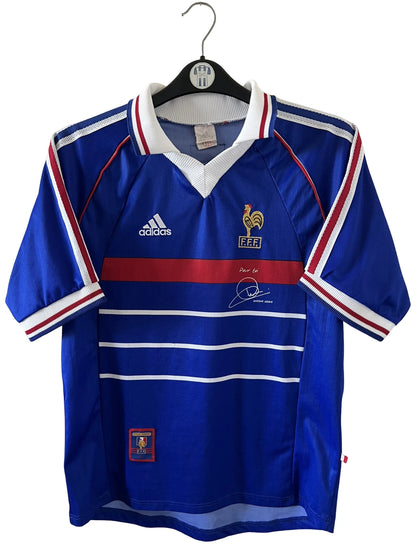 Maillot foot vintage domicile equipe de france 1998 bleu blanc et rouge. On peut retrouver l'équipementier adidas. Il s'agit d'un maillot authentique d'époque avec la signature et l'édition pour toi Zidane.