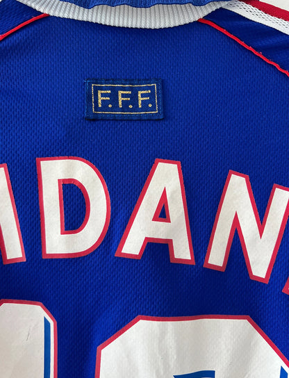 Maillot foot vintage domicile equipe de france 1998 bleu blanc et rouge. On peut retrouver l'équipementier adidas. Ils 'agit d'un maillot authentique d'époque floqué Zinedine Zidane