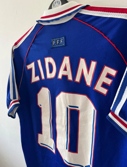 Maillot foot vintage domicile equipe de france 1998 bleu blanc et rouge. On peut retrouver l'équipementier adidas. Ils 'agit d'un maillot authentique d'époque floqué Zinedine Zidane