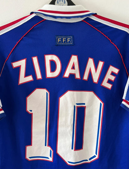 Maillot foot vintage domicile equipe de france 1998 bleu blanc et rouge. On peut retrouver l'équipementier adidas. Ils 'agit d'un maillot authentique d'époque floqué Zinedine Zidane