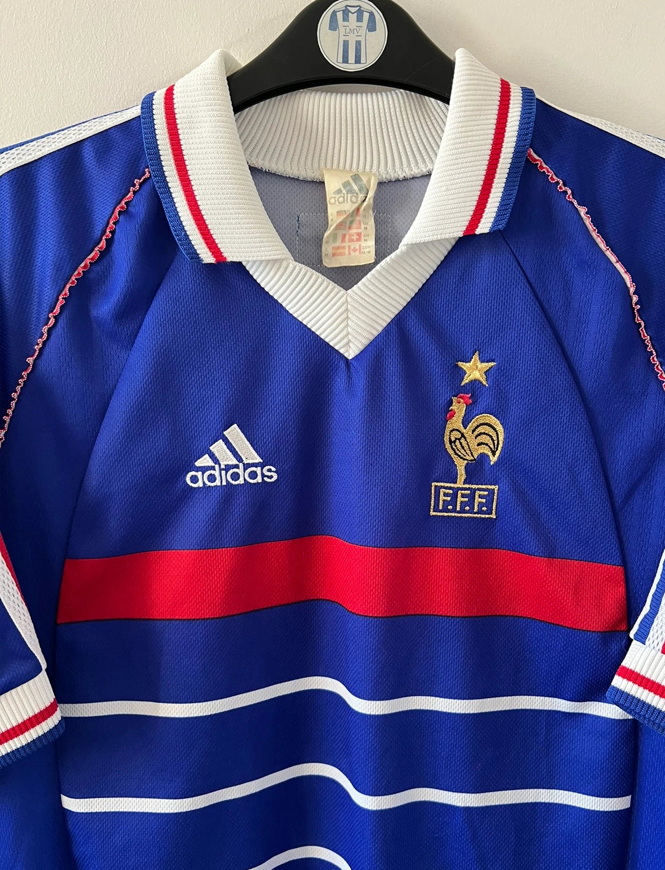 Maillot de foot vintage domicile bleu blanc et rouge de l'équipe de france 1998. On peut retrouver l'équipementier Adidas. Il s'agit d'un maillot authentique d'époque.
