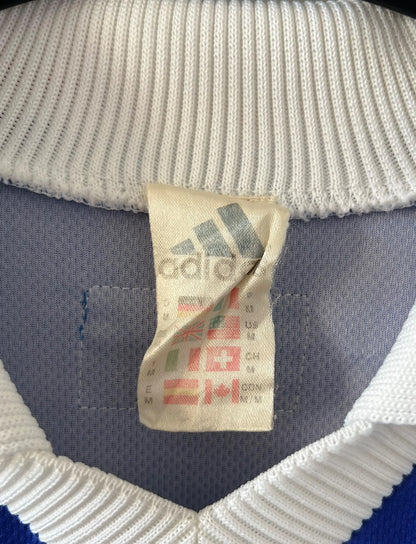 Maillot de foot vintage domicile bleu blanc et rouge de l'équipe de france 1998. On peut retrouver l'équipementier Adidas. Il s'agit d'un maillot authentique d'époque.