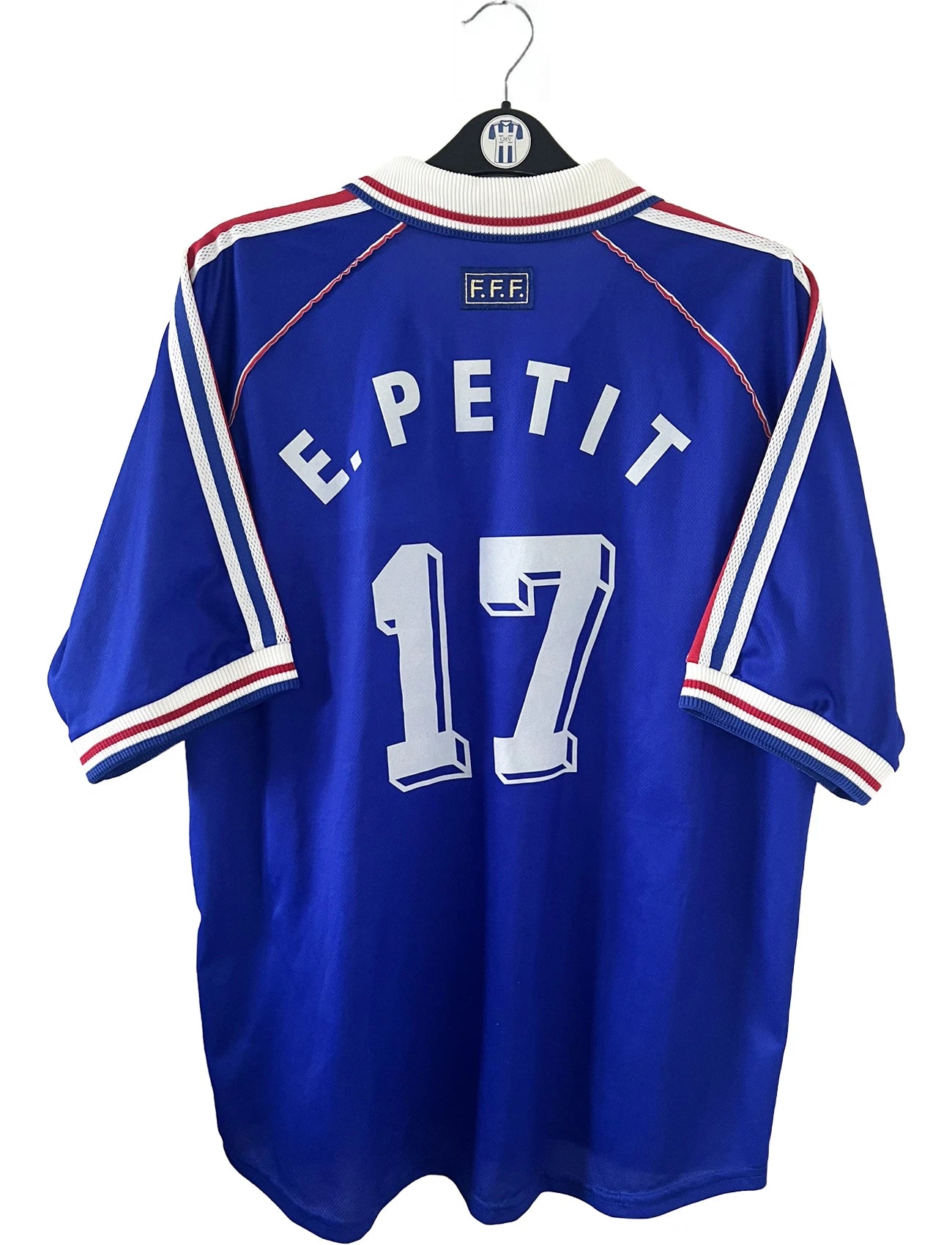 Maillot de foot vintage domicile bleu, blanc et rouge de l'équipe de france 1998. On peut retrouver l'équipementier adidas. Le maillot est floqué du numéro 17 Emmaunel Petit. Il s'agit d'un maillot authentique d'époque