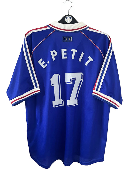 Maillot de foot vintage domicile bleu, blanc et rouge de l'équipe de france 1998. On peut retrouver l'équipementier adidas. Le maillot est floqué du numéro 17 Emmaunel Petit. Il s'agit d'un maillot authentique d'époque