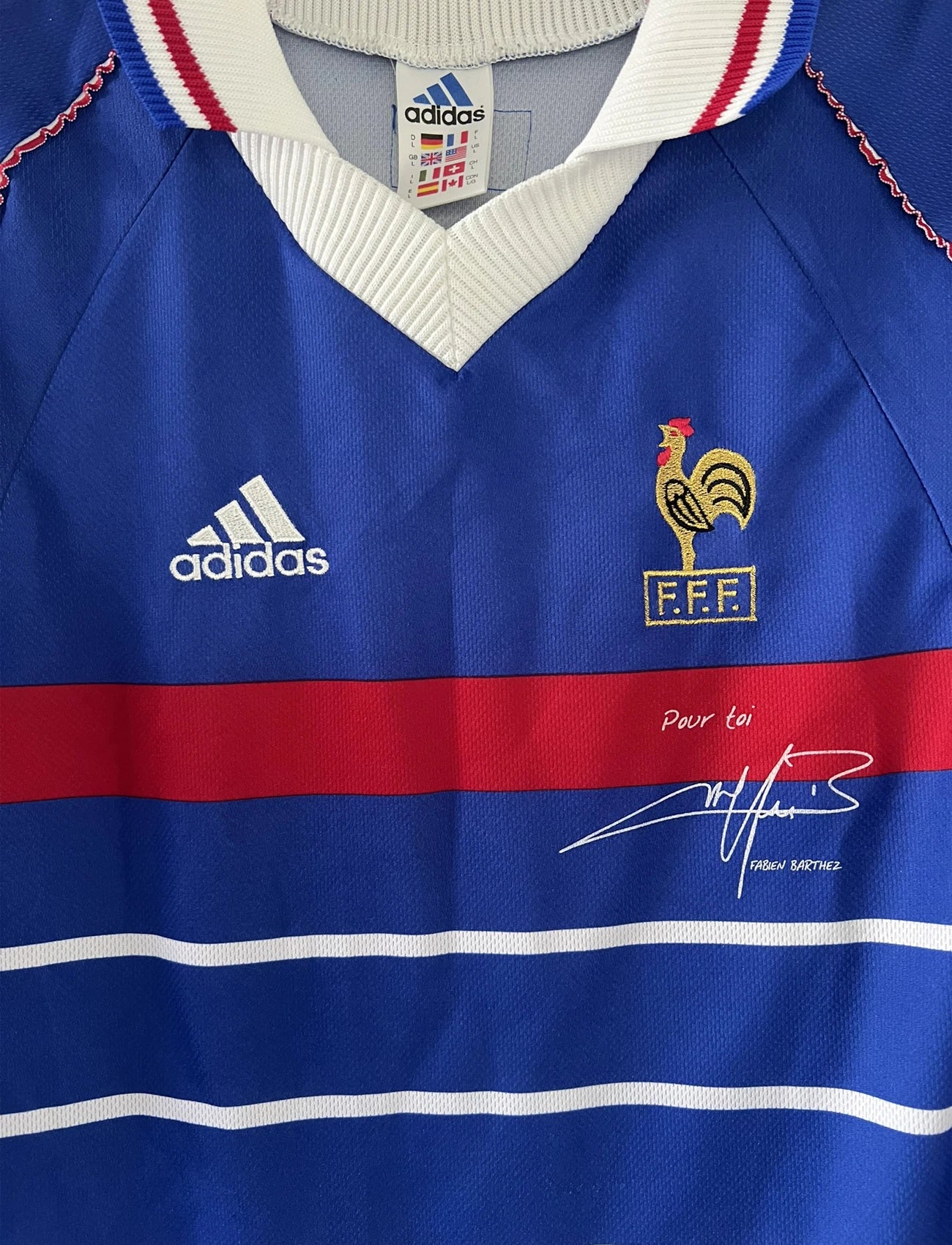Maillot de foot vintage domicile bleu de l'équipe de france 1998. On peut retrouver l'équipementier adidas. Le maillot est signé avec la mention pour toi fabien barthez. Il s'agit d'un maillot authentique d'époque.