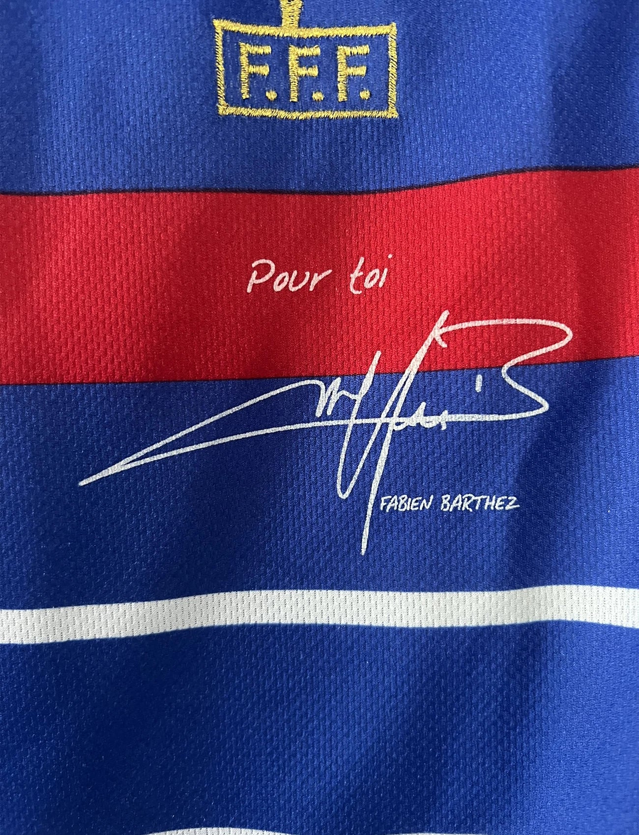 Maillot de foot vintage domicile bleu de l'équipe de france 1998. On peut retrouver l'équipementier adidas. Le maillot est signé avec la mention pour toi fabien barthez. Il s'agit d'un maillot authentique d'époque.