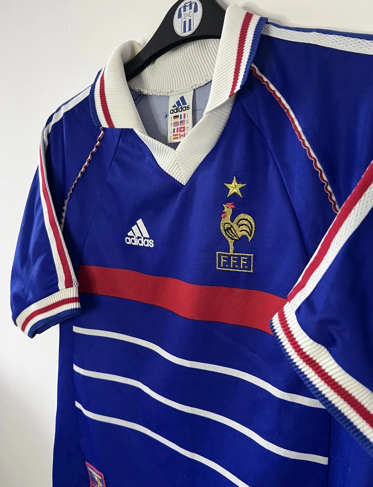 Maillot de foot vintage domicile bleu de l'équipe de france 1998. On peut retrouver l'équipementier Adidas. Le maillot est floqué du numéro 10 Zinedine Zidane. Il s'agit d'un maillot authentique d'époque.