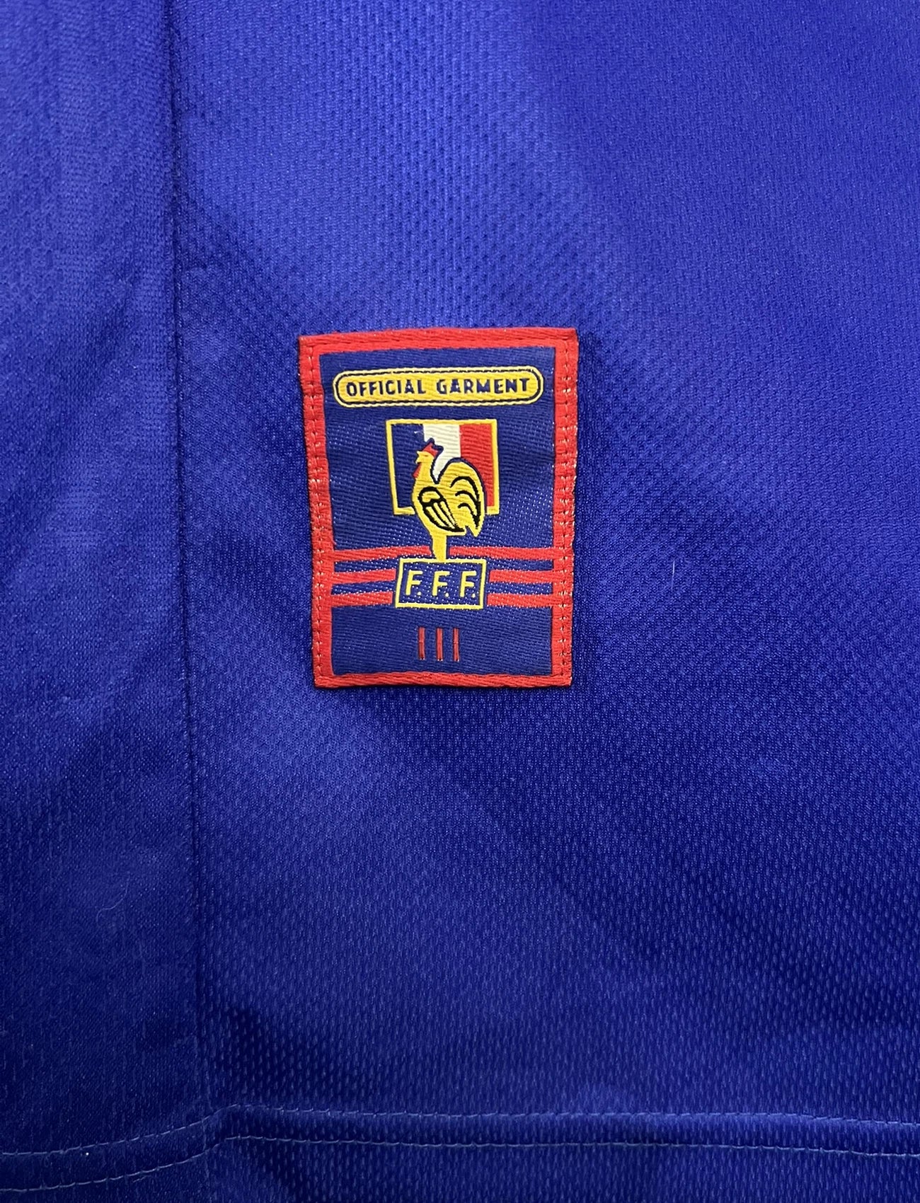 Maillot de foot vintage domicile bleu de l'équipe de france 1998. On peut retrouver l'équipementier Adidas. Le maillot est floqué du numéro 10 Zinedine Zidane. Il s'agit d'un maillot authentique d'époque.