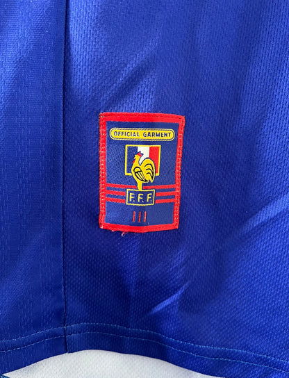Maillot de foot vintage domicile bleu blanc et rouge de l'équipe de france 1998. On peut retrouver l'équipementier Adidas. Le maillot est floqué du numéro 10 Zinedine Zidane. Il s'agit d'un maillot authentique d'époque.