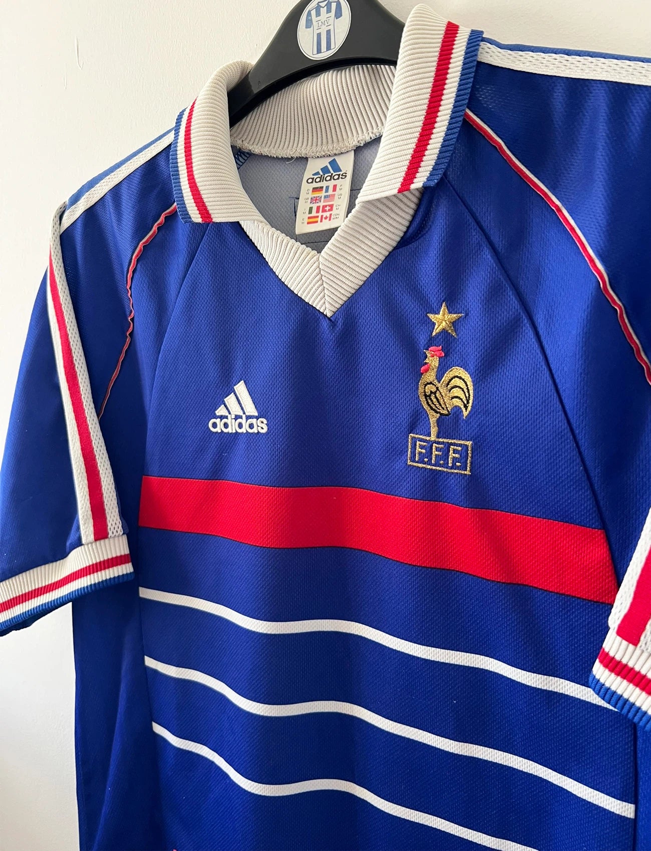 Maillot de foot vintage domicile bleu de l'Equipe de France 1998. On peut retrouver l'équipementier Adidas. Le maillot est floqué du numéro 10 Zinedine Zidane. Il s'agit d'un maillot authentique d'époque.