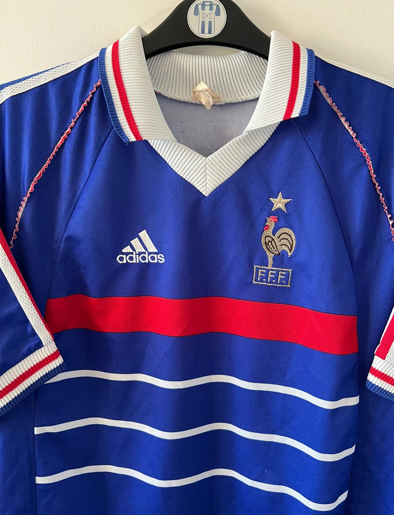 Maillot de foot vintage domicile bleu de l'Equipe de France 1998. On peut retrouver l'équipementier Adidas. Le maillot est floqué du numéro 10 Zinedine Zidane. Il s'agit d'un maillot authentique d'époque.