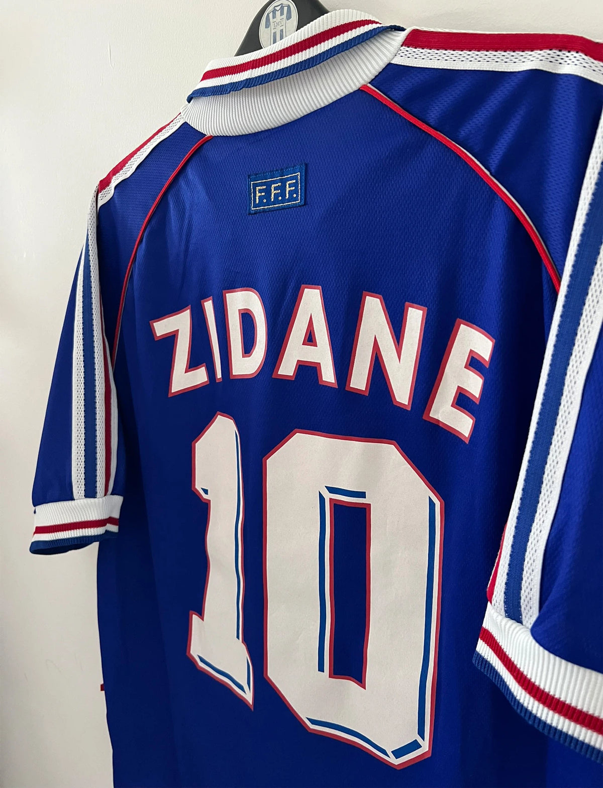 Maillot foot vintage domicile equipe de france 1998 bleu blanc et rouge. On peut retrouver l'équipementier adidas. Le maillot est floqué du numéro 10 Zinedine Zidane. Il s'agit d'un maillot authentique d'époque vendu avec son short d'époque.