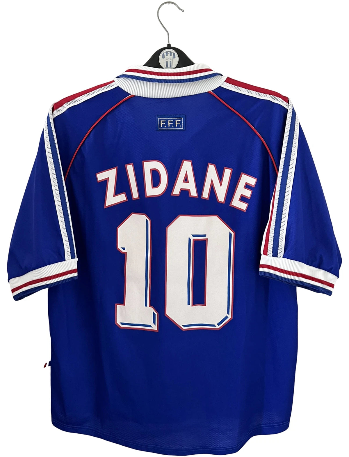 Maillot foot vintage domicile equipe de france 1998 bleu blanc et rouge. On peut retrouver l'équipementier adidas. Le maillot est floqué du numéro 10 Zinedine Zidane. Il s'agit d'un maillot authentique d'époque vendu avec son short d'époque.