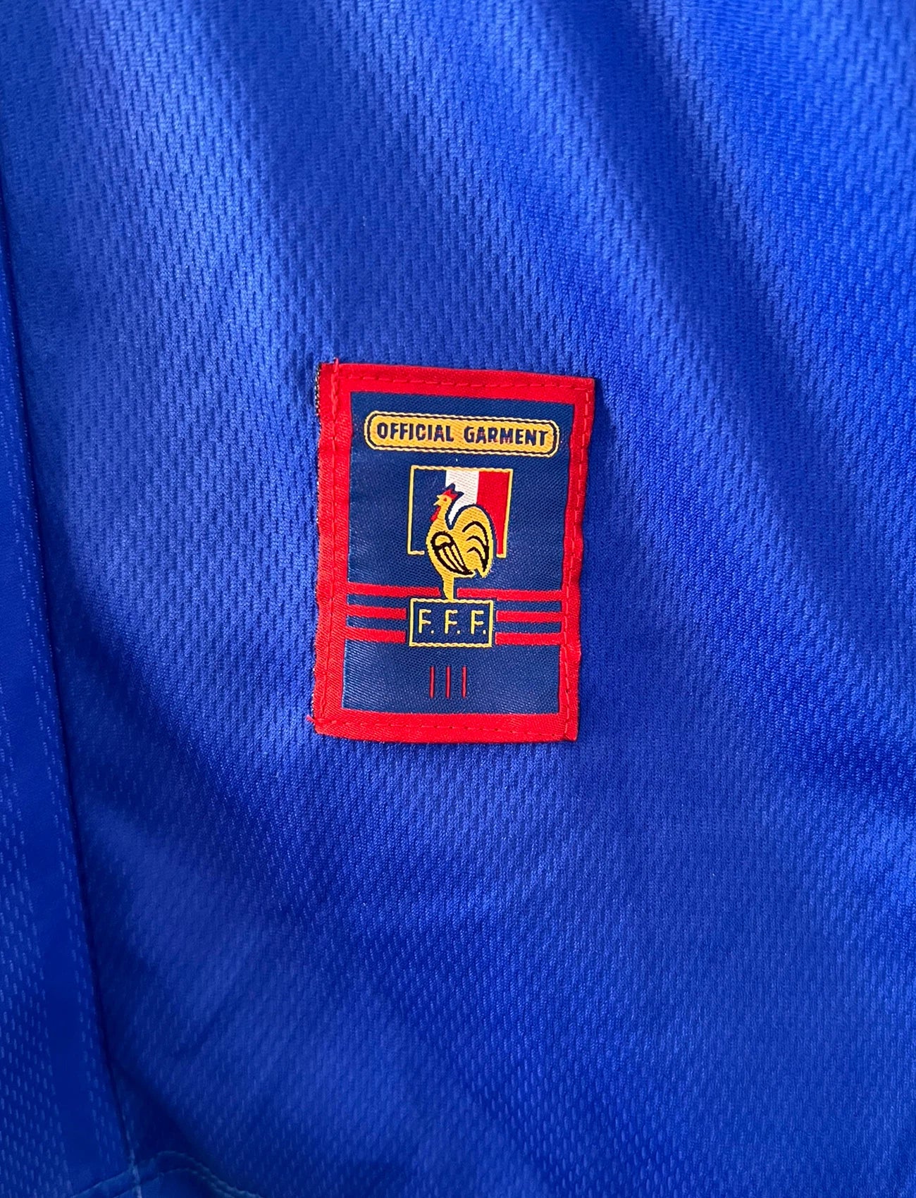 Maillot de foot vintage domicile bleu de l'équipe de france 1998. On peut retrouver l'équipementier Adidas. Le maillot est floqué du numéro 10 Zinedine Zidane. Il s'agit d'un maillot authentique d'époque.