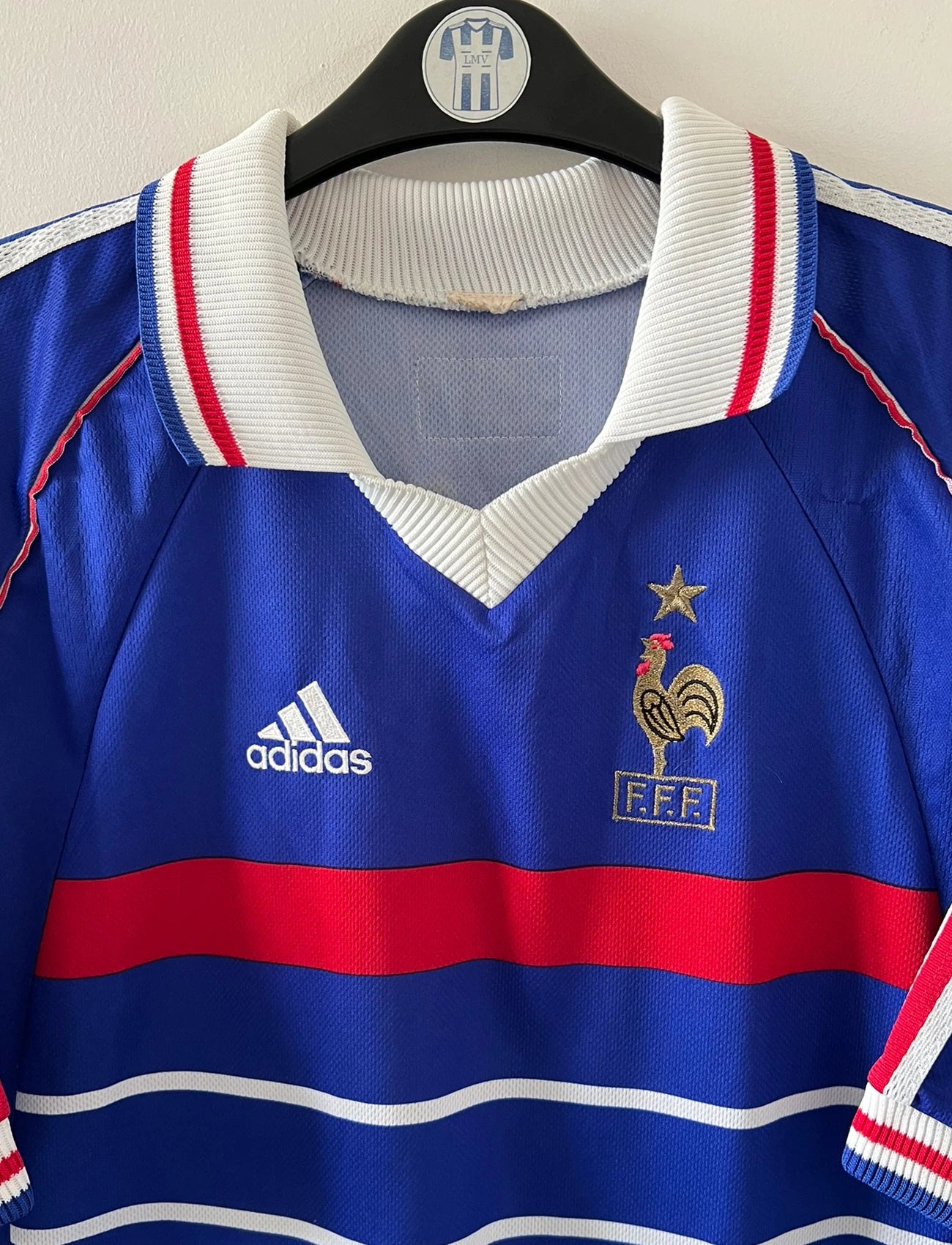 Maillot de foot vintage domicile bleu de l'équipe de france 1998. On peut retrouver l'équipementier Adidas. Le maillot est floqué du numéro 10 Zinedine Zidane. Il s'agit d'un maillot authentique d'époque.