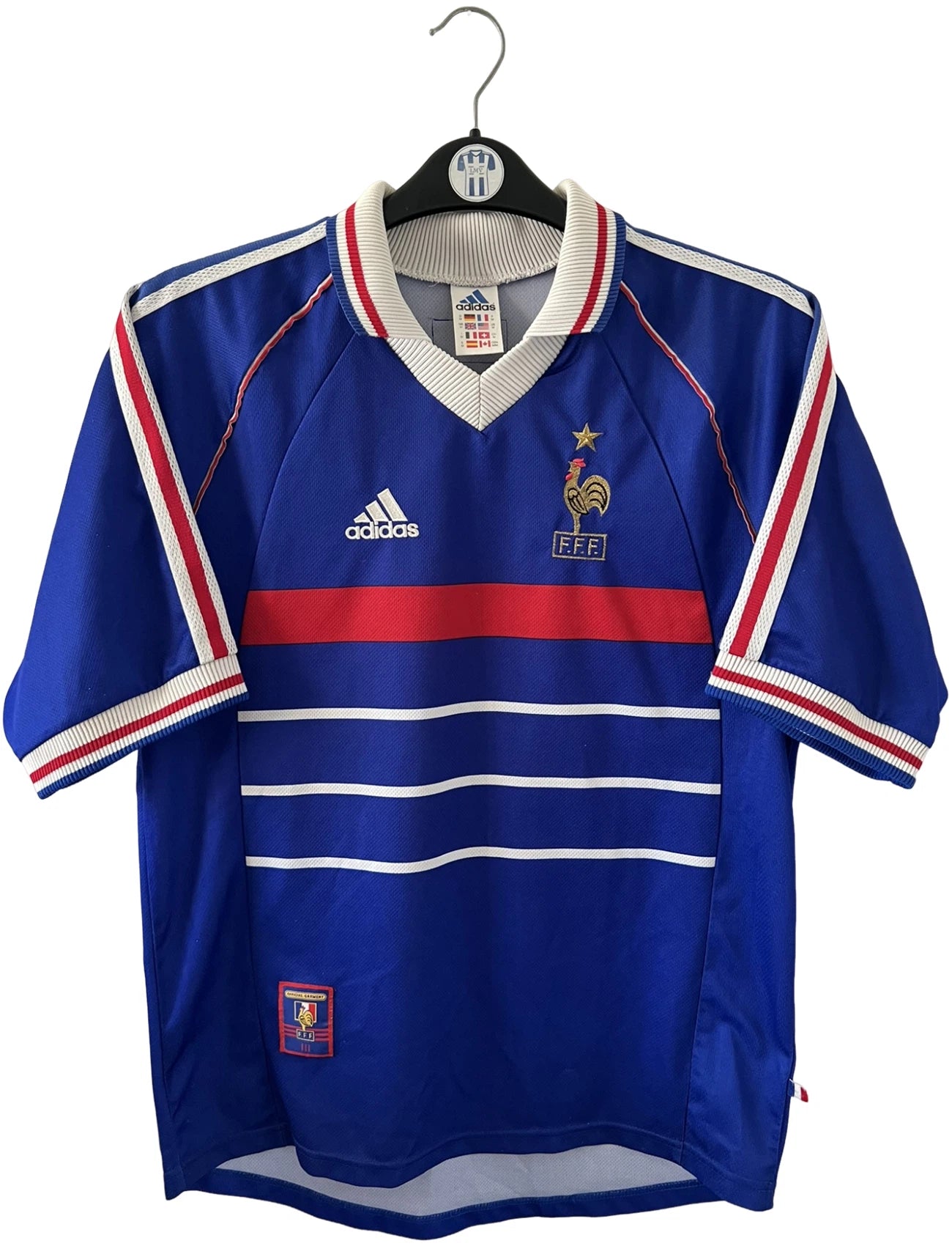 Maillot de foot vintage domicile bleu de l'Equipe de France 1998. On peut retrouver l'équipementier Adidas. Le maillot est floqué du numéro 10 Zinedine Zidane. Il s'agit d'un maillot authentique d'époque.