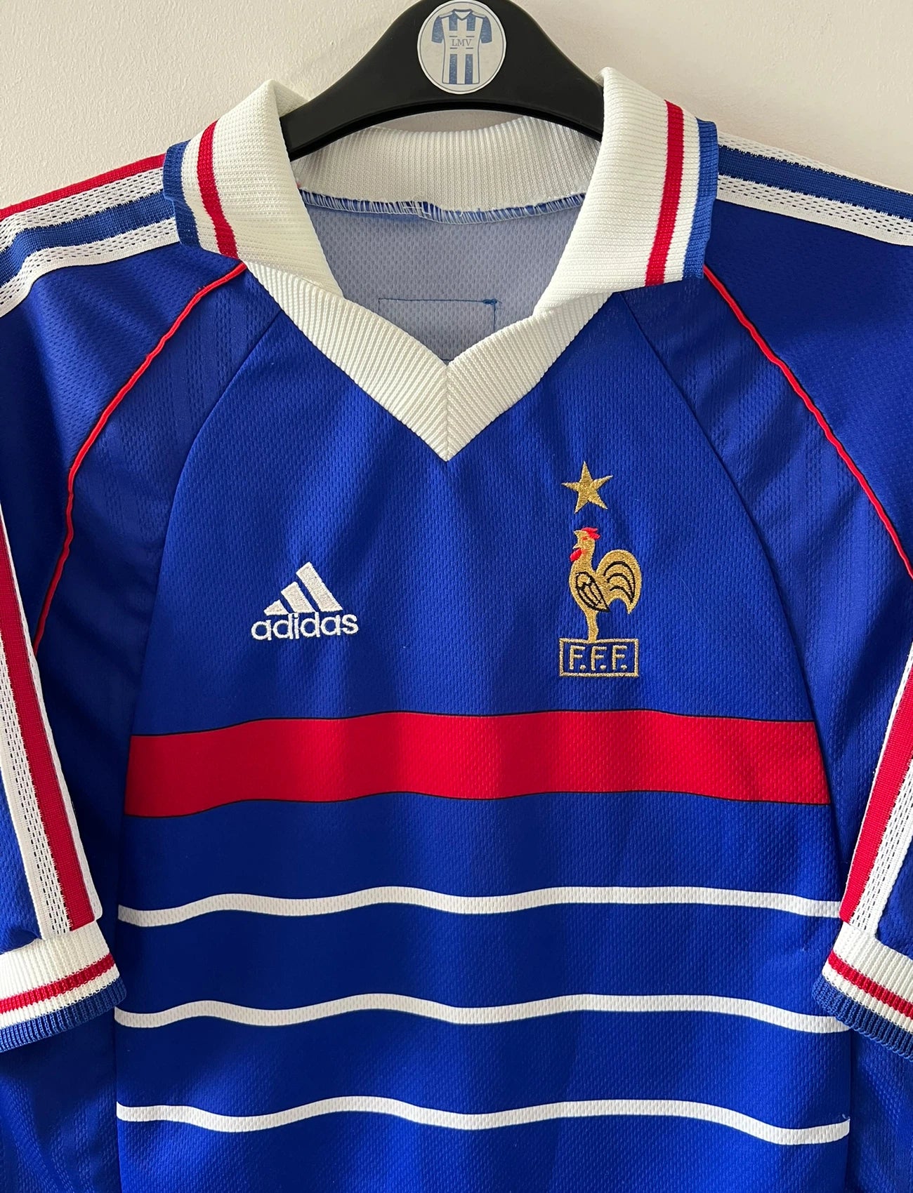 Maillot de foot vintage domicile bleu de l'équipe de france 1998. On peut retrouver l'équipementier Adidas. Le maillot est floqué du numéro 10 Zinedine Zidane. Il s'agit d'un maillot authentique d'époque.