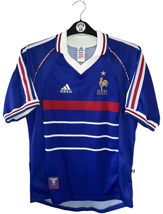 Maillot de foot vintage domicile bleu de l'équipe de france 1998. On peut retrouver l'équipementier Adidas. Il s'agit d'un maillot authentique d'époque.