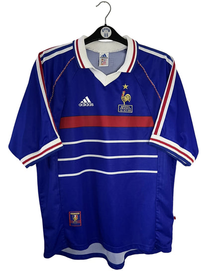Maillot de foot vintage domicile bleu de l'Equipe de France 1998. On peut retrouver l'équipementier Adidas. Il s'agit d'un maillot authentique d'époque.