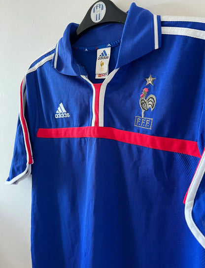 Maillot de foot vintage domicile bleu de l'équipe de france 2000. On peut retrouver l'équipementier Adidas. Il s'agit d'un maillot authentique d'époque.