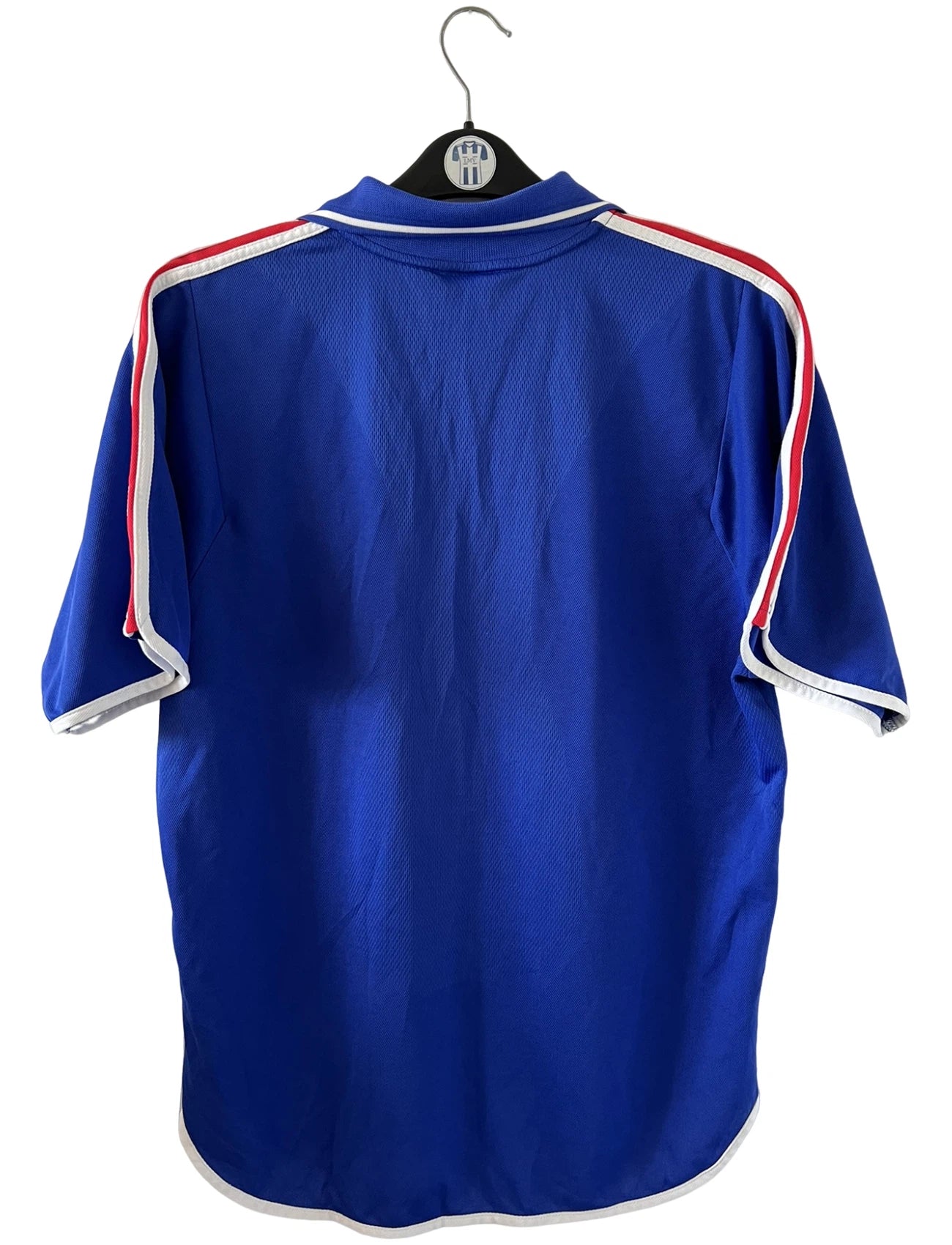 Maillot de foot vintage domicile bleu de l'équipe de france 2000. On peut retrouver l'équipementier Adidas. Il s'agit d'un maillot authentique d'époque.