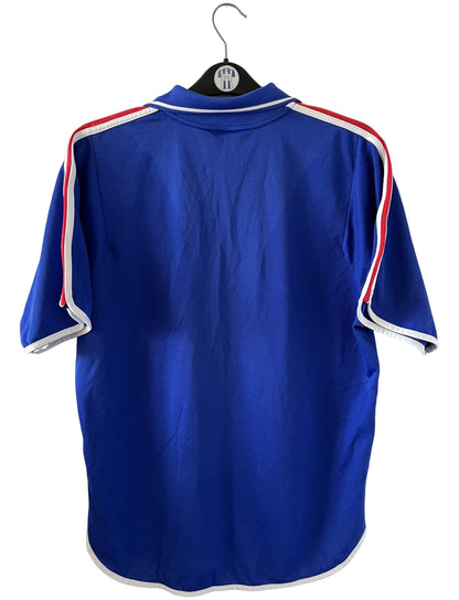 Maillot de foot vintage domicile bleu de l'équipe de france 2000. On peut retrouver l'équipementier Adidas. Il s'agit d'un maillot authentique d'époque.