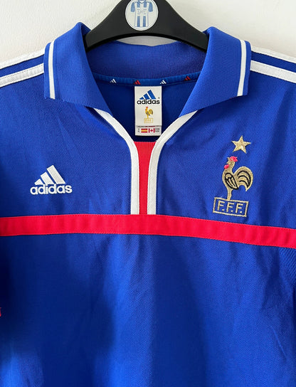 Maillot de foot vintage domicile bleu de l'Equipe de France 2000. On peut retrouver l'équipementier Adidas. Il s'agit d'un maillot authentique d'époque.