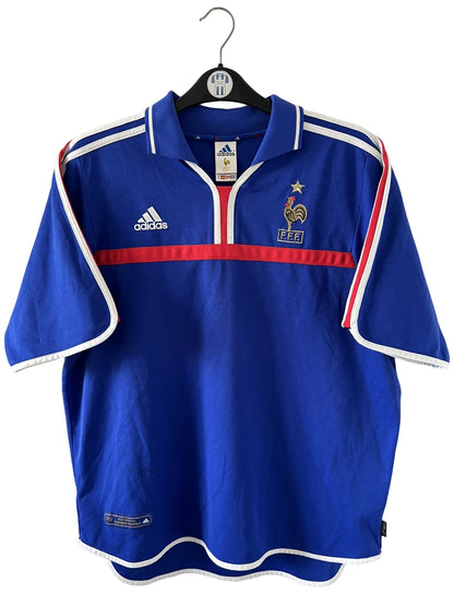 Maillot de foot vintage domicile bleu de l'Equipe de France 2000. On peut retrouver l'équipementier Adidas. Il s'agit d'un maillot authentique d'époque.
