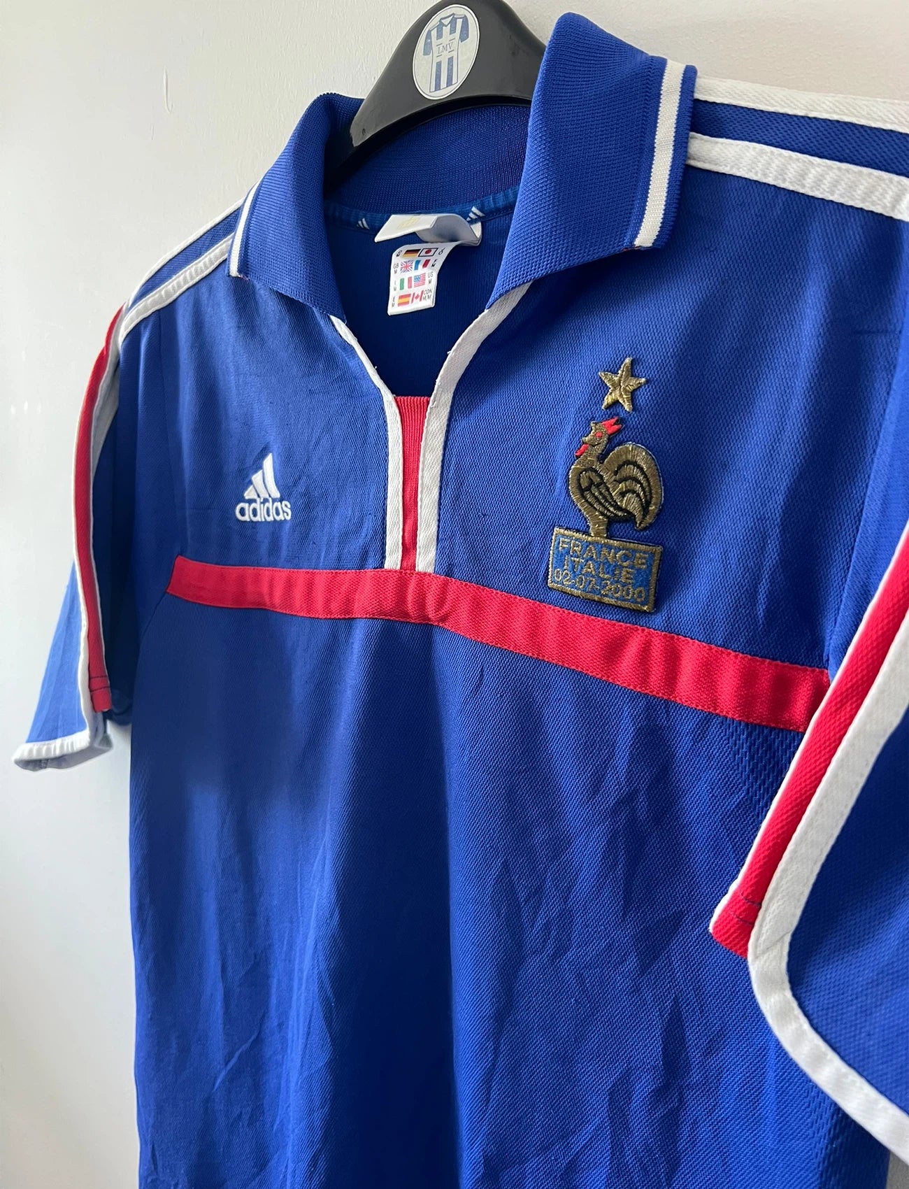 Maillot de foot vintage domicile bleu de l'équipe de france 2000. On peut retrouver l'équipementier Adidas et le flocage de Zinedine Zidane. Il s'agit d'un maillot authentique d'époque.