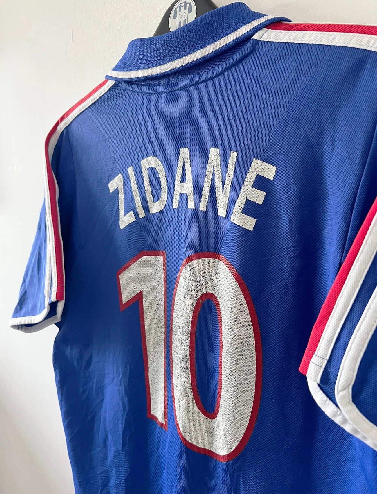 Maillot de foot vintage domicile bleu de l'équipe de france 2000. On peut retrouver l'équipementier Adidas et le flocage de Zinedine Zidane. Il s'agit d'un maillot authentique d'époque.