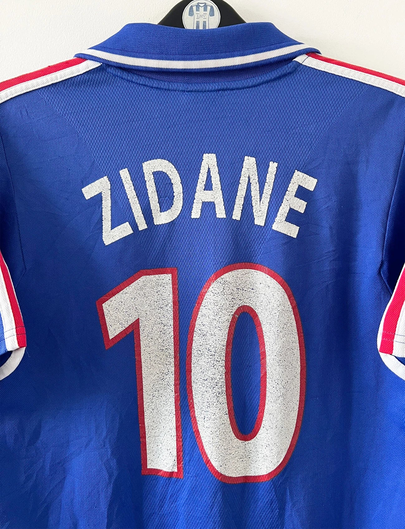 Maillot de foot vintage domicile bleu de l'équipe de france 2000. On peut retrouver l'équipementier Adidas et le flocage de Zinedine Zidane. Il s'agit d'un maillot authentique d'époque.