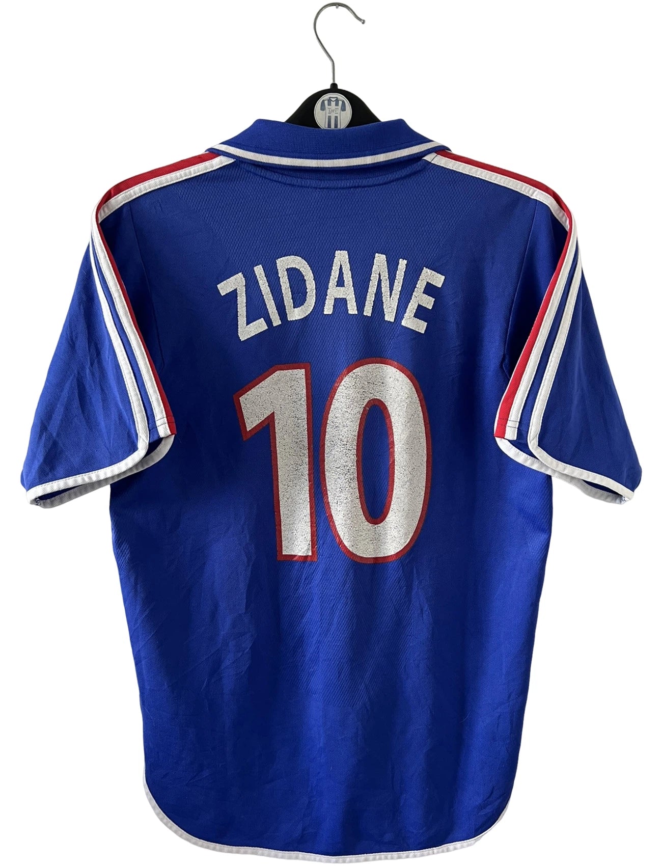 Maillot de foot vintage domicile bleu de l'équipe de france 2000. On peut retrouver l'équipementier Adidas et le flocage de Zinedine Zidane. Il s'agit d'un maillot authentique d'époque.