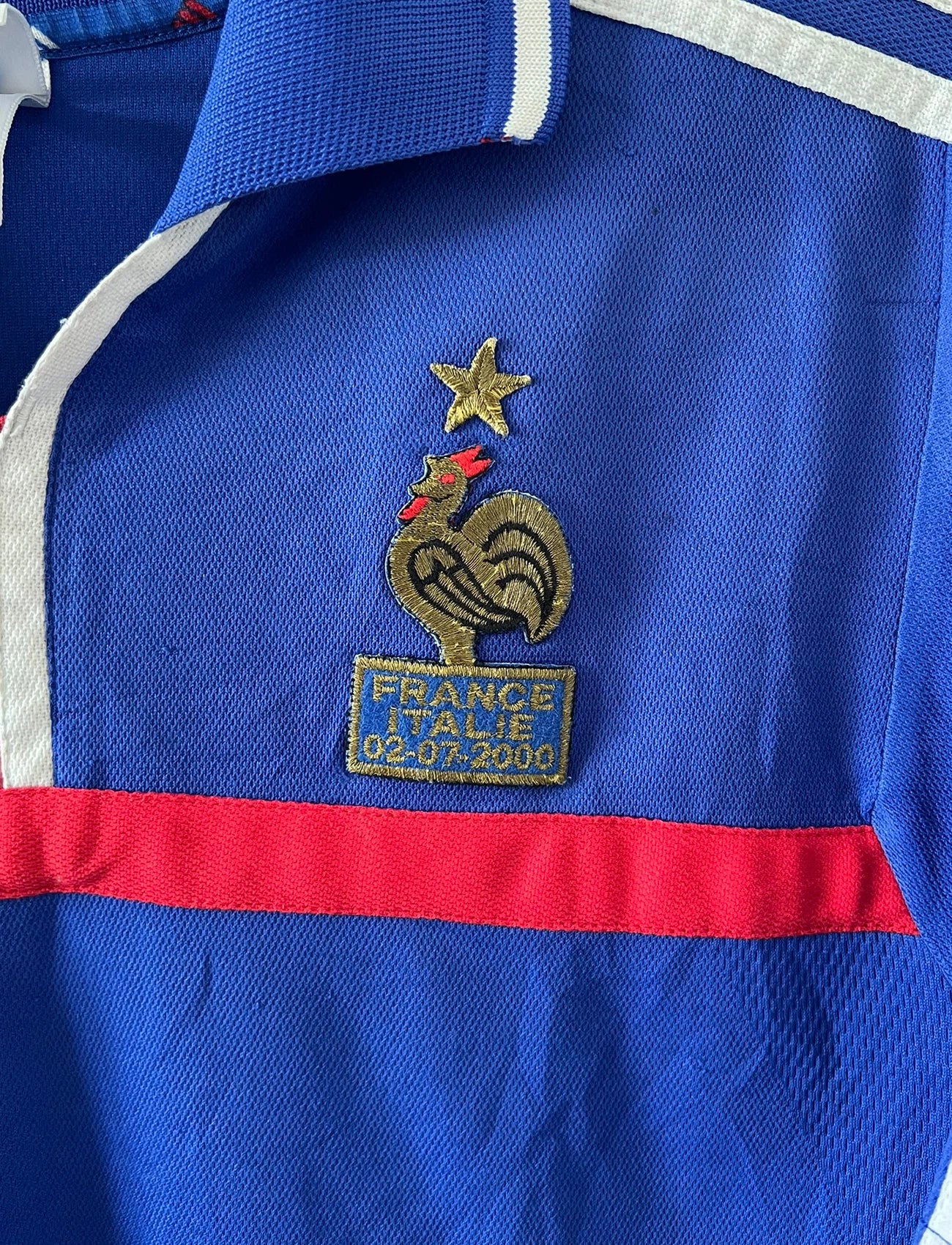 Maillot de foot vintage domicile bleu de l'équipe de france 2000. On peut retrouver l'équipementier Adidas et le flocage de Zinedine Zidane. Il s'agit d'un maillot authentique d'époque.