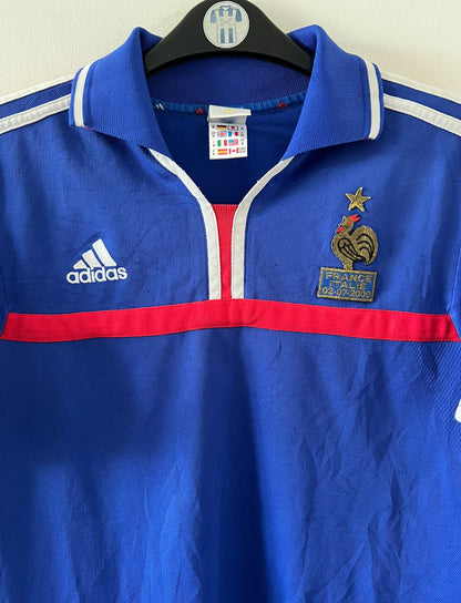 Maillot de foot vintage domicile bleu de l'équipe de france 2000. On peut retrouver l'équipementier Adidas et le flocage de Zinedine Zidane. Il s'agit d'un maillot authentique d'époque.