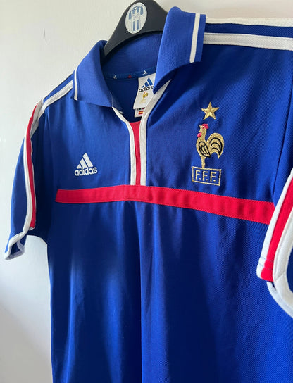 Maillot de foot vintage domicile bleu de l'Equipe de France 2000. On peut retrouver l'équipementier Adidas. Le maillot est floqué du numéro 10 Zinedine Zidane. Il s'agit d'un maillot authentique d'époque.