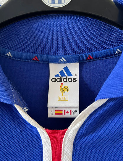 Maillot de foot vintage domicile bleu de l'Equipe de France 2000. On peut retrouver l'équipementier Adidas. Le maillot est floqué du numéro 10 Zinedine Zidane. Il s'agit d'un maillot authentique d'époque.