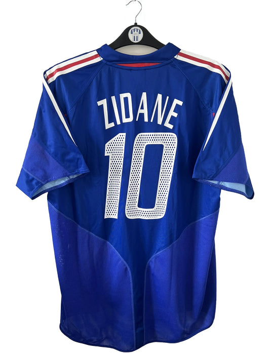 Maillot de foot vintage domicile de l'équipe de france 2004/2006. On peut retrouver l'équipementier adidas. Le maillot est floqué du numéro 10 Zinedine Zidane. Il s'agit d'un maillot authentique d'époque comportant l'étiquette 600222.