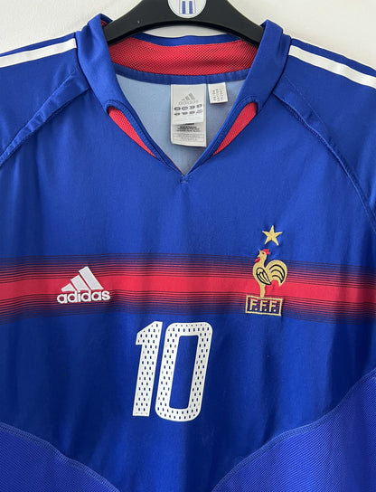 Maillot de foot vintage domicile bleu blanc et rouge de l'équipe de france 2004. On peut retrouver l'équipementier adidas. Il s'agit d'un maillot authentique d'époque comportant le numéro 641768