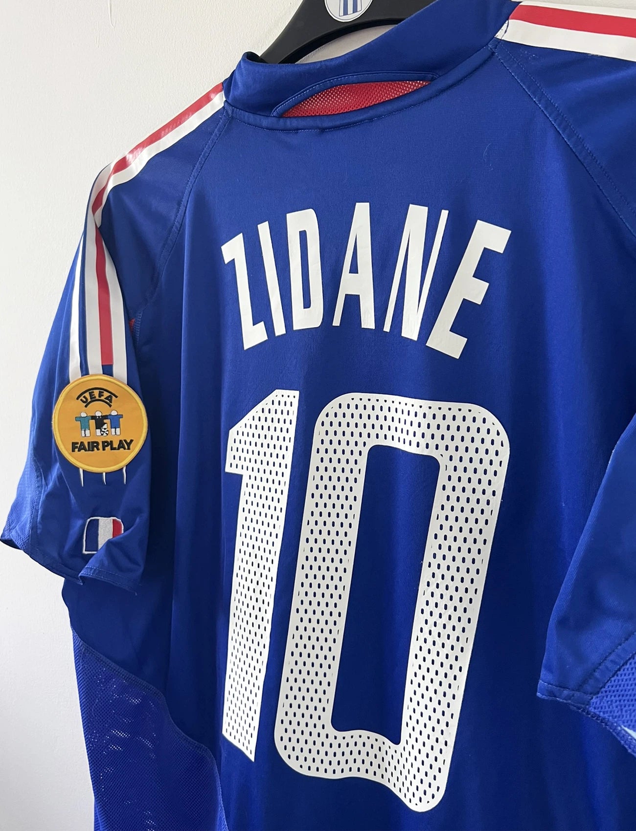 Maillot de foot vintage domicile bleu blanc et rouge de l'équipe de france 2004. On peut retrouver l'équipementier adidas. Il s'agit d'un maillot authentique d'époque comportant le numéro 641768