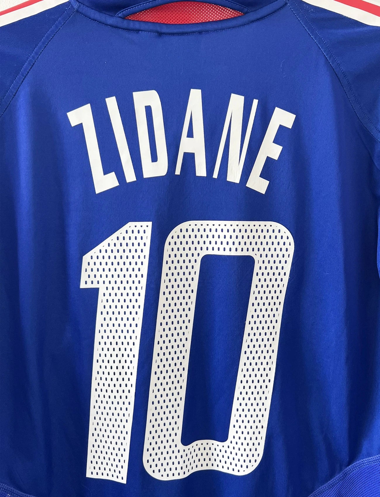 Maillot de foot vintage domicile bleu blanc et rouge de l'équipe de france 2004. On peut retrouver l'équipementier adidas. Il s'agit d'un maillot authentique d'époque comportant le numéro 641768