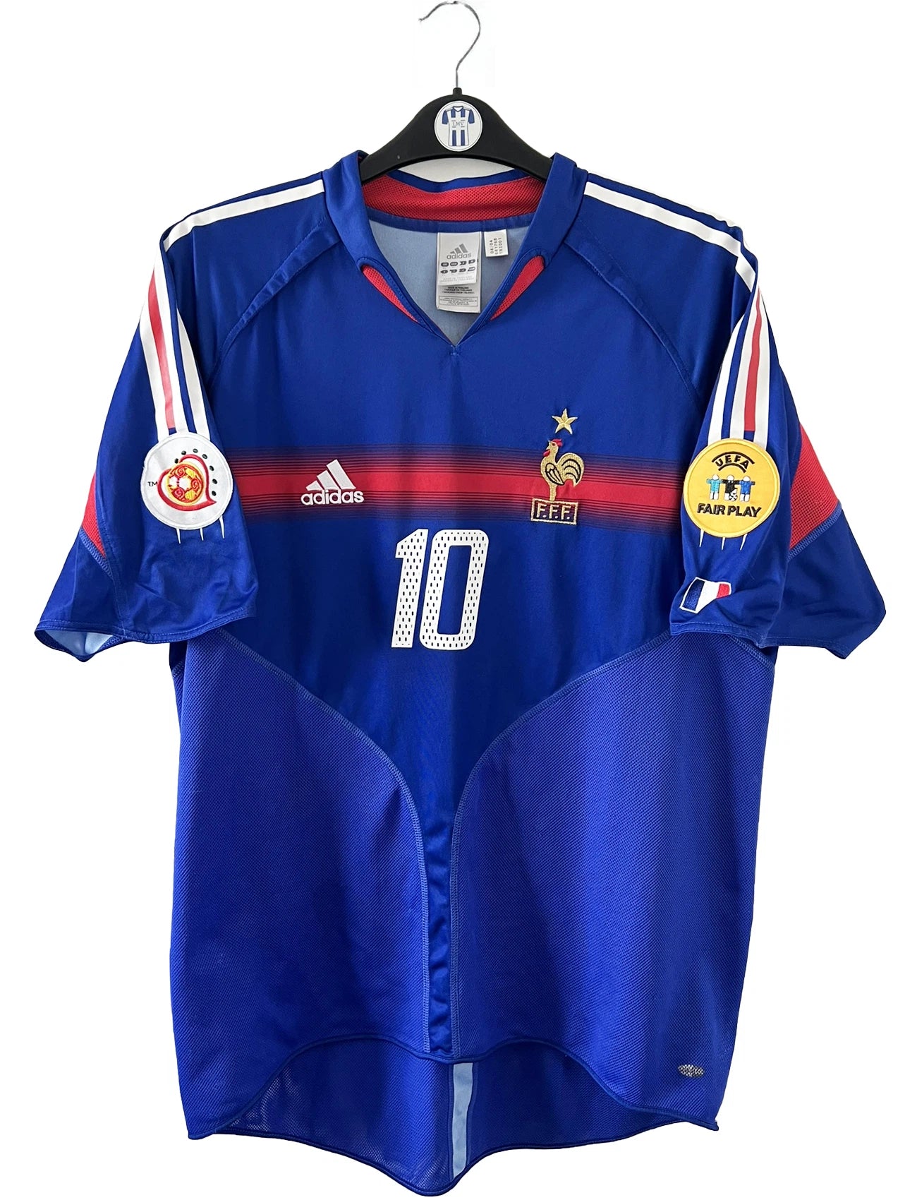 Maillot de foot vintage domicile bleu blanc et rouge de l'équipe de france 2004. On peut retrouver l'équipementier adidas. Il s'agit d'un maillot authentique d'époque comportant le numéro 641768
