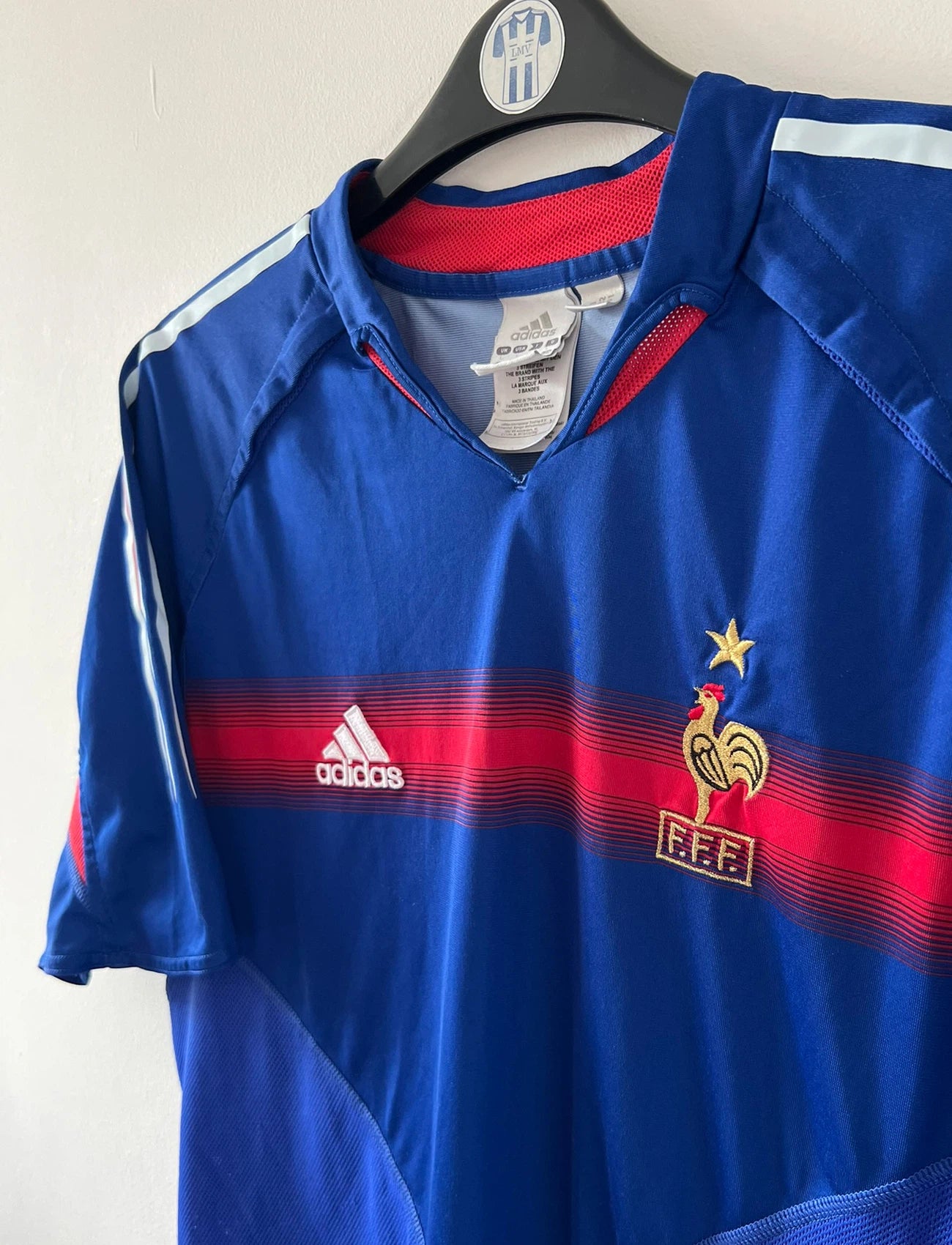 Maillot de foot vintage domicile bleu de l'Equipe de France 2004. On peut retrouver l'équipementier Adidas. Le maillot est floqué du numéro 10 Zinedine Zidane. Il s'agit d'un maillot authentique d'époque.